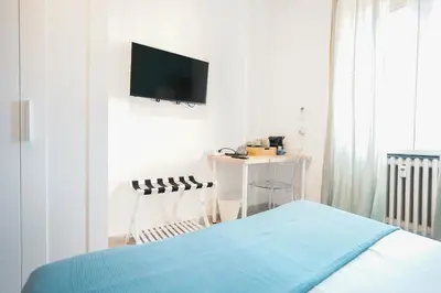 a bedroom with a bed and a tv on a wall at Salotto Tiburtino in Rome