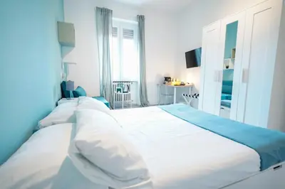 a bedroom with a large bed with white and blue sheets at Salotto Tiburtino in Rome