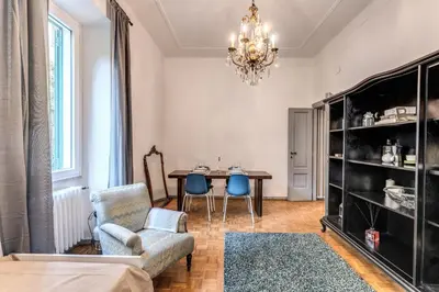 a living room with a table and chairs and a chandelier at Residenza Nemorense in Rome