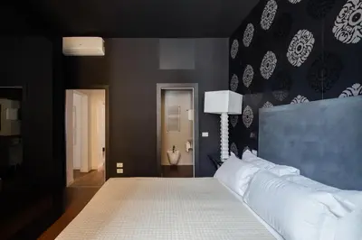 a bedroom with a large bed with a blue wall at 2 bedrooms flat near Via Veneto in Rome