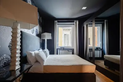a bedroom with a bed and two windows at 2 bedrooms flat near Via Veneto in Rome