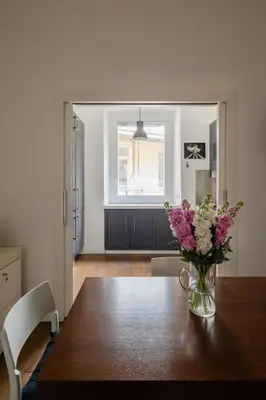 a dining room table with a vase of flowers on it at 2 bedrooms flat near Via Veneto in Rome
