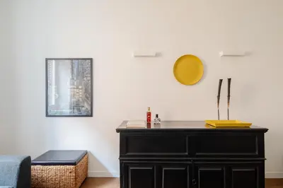 a living room with a black dresser and a mirror at 2 bedrooms flat near Via Veneto in Rome