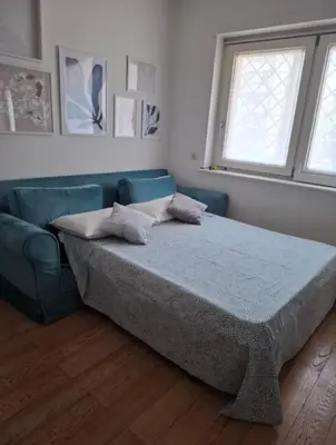 a bedroom with a bed and a blue couch at La casa di Rosina al Pigneto in Rome
