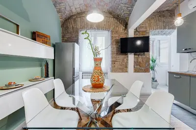 a kitchen with a glass table and white chairs at Clemente XII Repubblica House - 3 Bedroom Apartment in Rome
