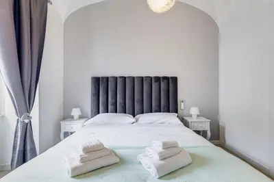 a bedroom with a large white bed with two towels on it at Clemente XII Repubblica House - 3 Bedroom Apartment in Rome