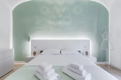 a bedroom with a large white bed with two towels at Clemente XII Repubblica House - 3 Bedroom Apartment in Rome