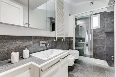 a white bathroom with a sink and a toilet at Clemente XII Repubblica House - 3 Bedroom Apartment in Rome