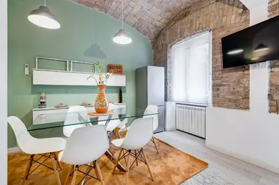 a dining room with a glass table and white chairs at Clemente XII Repubblica House - 3 Bedroom Apartment in Rome