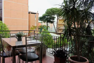 a balcony with a table and chairs and a plant at Mary's Suite Aventino in Rome