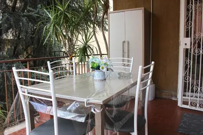 a white table with chairs and a refrigerator at Mary's Suite Aventino in Rome