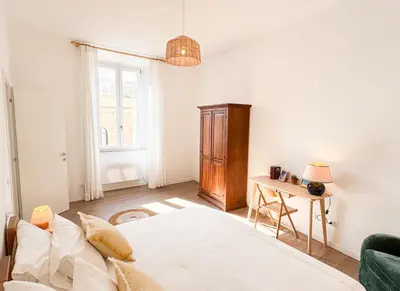 a white bedroom with a bed and a table at Bright Vatican Apartment in Rome