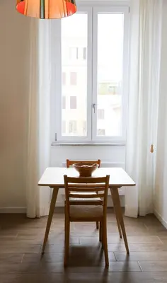 a dining room table with a chair and a window at Bright Vatican Apartment in Rome