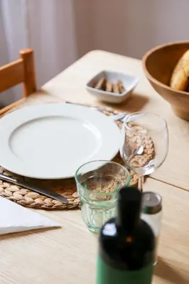 a wooden table with a white plate and glasses on it at Bright Vatican Apartment in Rome