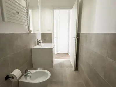 a white bathroom with a sink and a toilet at Bright Vatican Apartment in Rome