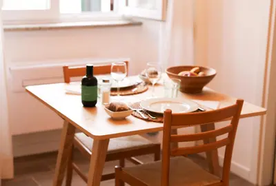 a wooden table with a bottle of wine and glasses at Bright Vatican Apartment in Rome
