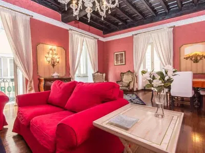 a red living room with a red couch and a table at Luxury Apartment Spanish Steps in Rome