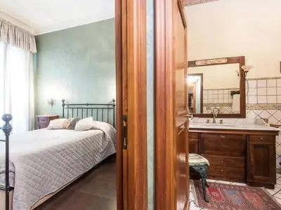 a bedroom with a bed and a sink and a mirror at Luxury Apartment Spanish Steps in Rome