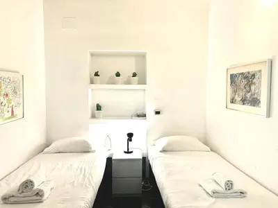 two beds in a room with white walls at Maison Borghetto - Vatican Flat in Rome