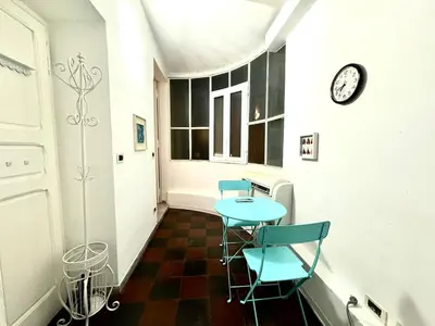 a hallway with two chairs and a table and a clock at Maison Borghetto - Vatican Flat in Rome