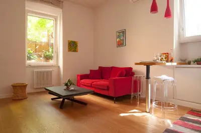 a living room with a red couch and a table at Perfect Hideout in Trastevere in Rome