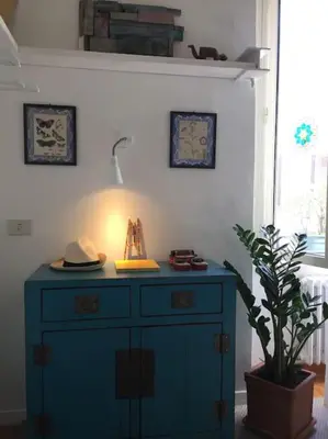a blue cabinet with a lamp and a plant in a room at Vatican Dolce Vita in Rome