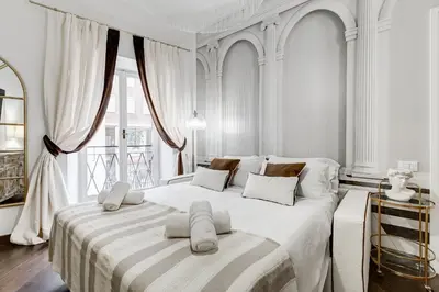 a white bedroom with a large bed with two pillows at NEXT TO SPANISH SQUARE - RomeDreamHome in Rome