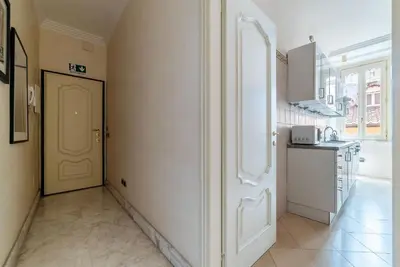 a kitchen with a white door in a room at JOIVY Window on the Tevere in Rome
