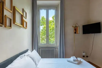 a bedroom with a white bed and a window at JOIVY Window on the Tevere in Rome