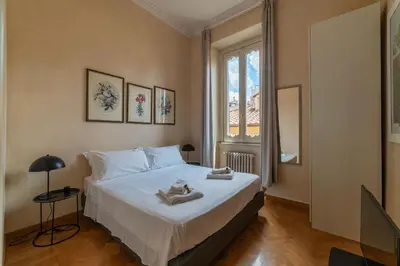 a bedroom with a bed with towels on it at JOIVY Window on the Tevere in Rome