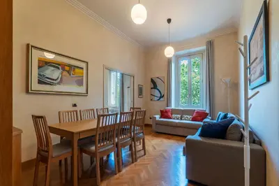 a living room with a table and chairs and a couch at JOIVY Window on the Tevere in Rome