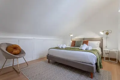 a bedroom with a bed and a chair at 18 Ciancaleoni House in Rome