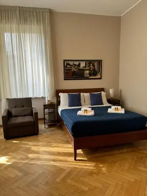 a bedroom with a large bed and a chair at Aventino Flat in Rome