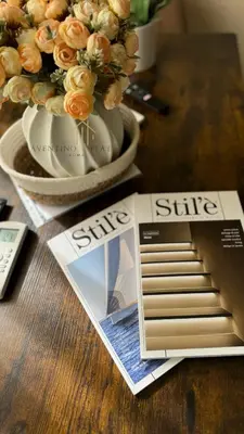a magazine sitting on a table next to a vase of flowers at Aventino Flat in Rome