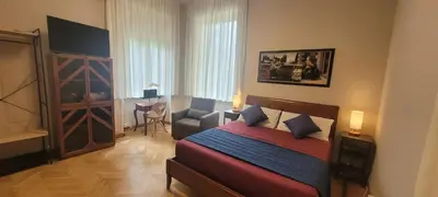 a bedroom with a bed and a desk in a room at Aventino Flat in Rome