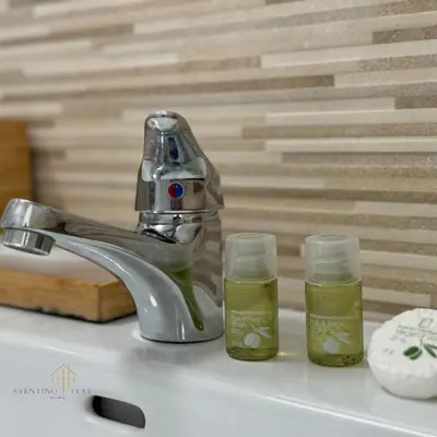 a sink with two bottles of green liquid next to a faucet at Aventino Flat in Rome