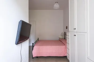 a bedroom with a bed and a flat screen tv at Vatican Cosy Apartment in Rome