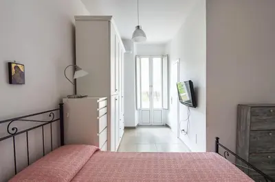 a bedroom with a bed and a hallway with a window at Vatican Cosy Apartment in Rome