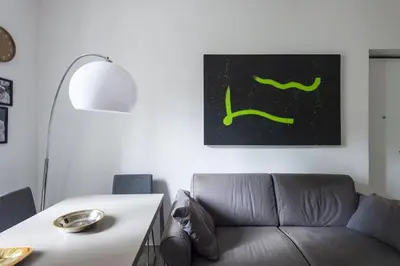 a living room with a couch and a painting on the wall at Vatican Cosy Apartment in Rome