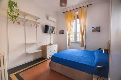 a bedroom with a blue bed and a window at Grazioli Vatican Home in Rome