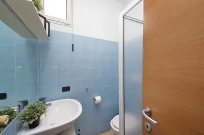 a blue tiled bathroom with a sink and a toilet at Monte del Gallo Apartment for groups in Rome