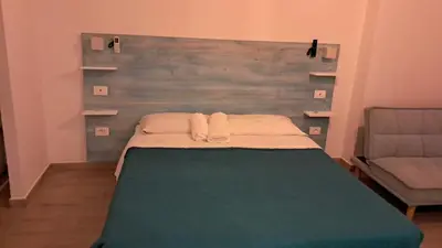 a bedroom with a bed with a headboard and a chair at Domus Turno by Local Domus in Rome