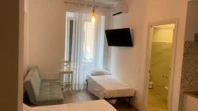 a small room with two beds and a television at Domus Turno by Local Domus in Rome