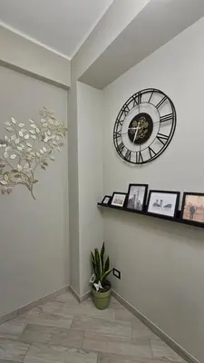 a clock on the wall in a room with pictures at AquariHome 6 Apartment in Rome
