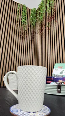 a coffee cup sitting on a table next to a book at AquariHome 6 Apartment in Rome