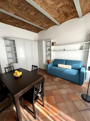 a living room with a table and a blue couch at TrastevereMoroni Gem in Rome