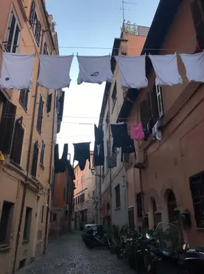 an alley with laundry hanging between two buildings at TrastevereMoroni Gem in Rome