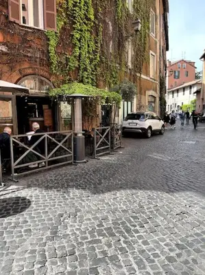 a cobblestone street with a building and an umbrella at TrastevereMoroni Gem in Rome