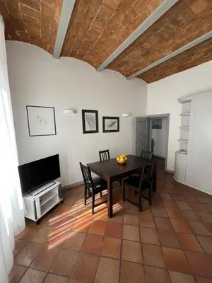 a dining room with a table and a tv at TrastevereMoroni Gem in Rome