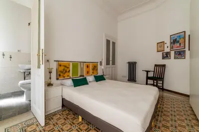 a white bedroom with a bed and a bathroom at Casa Dandolo - Pretty Homes in Rome